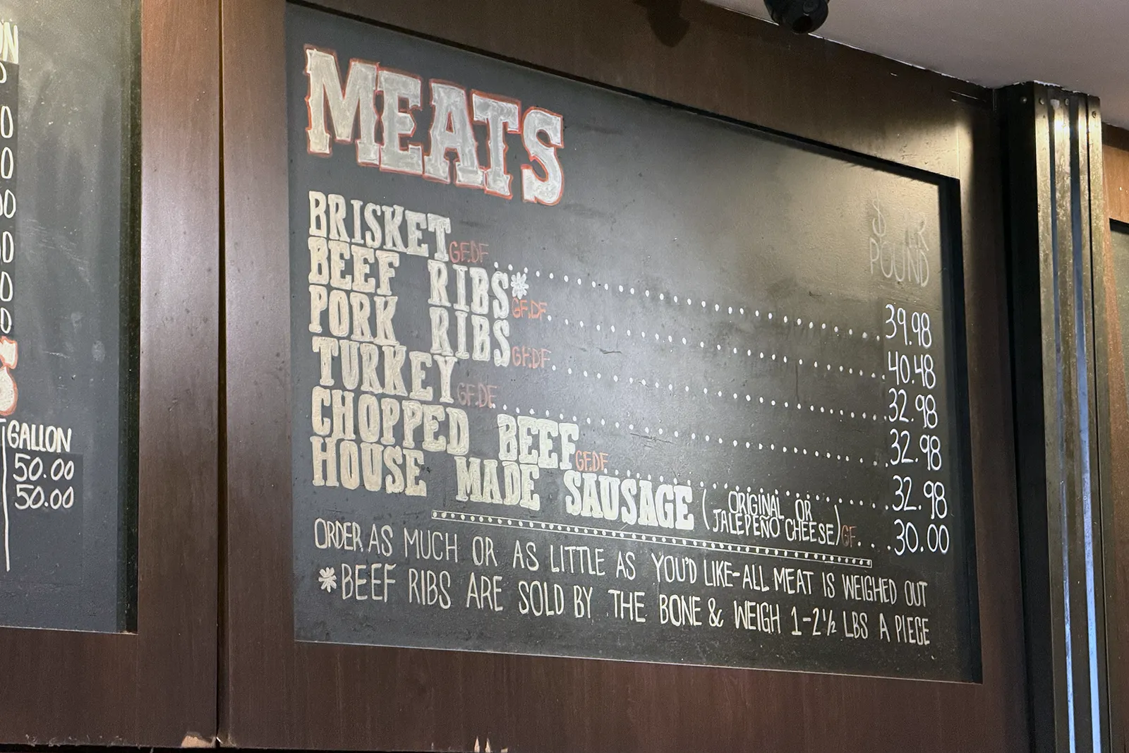 Terry Black’s chalkboard menu with barbecue meats and prices
