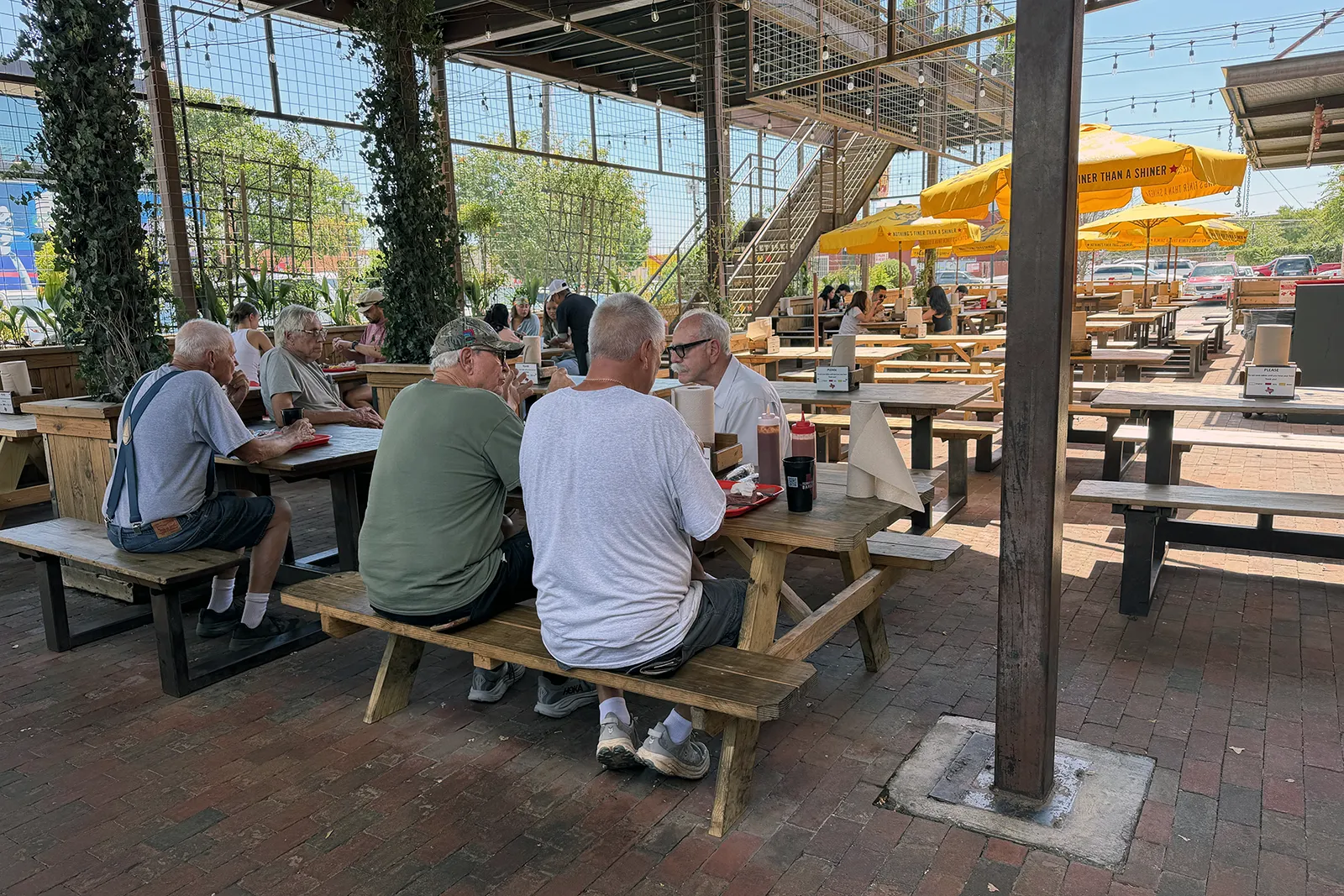 Covered outdoor patio with picnic tables at Terry Black’s Dallas